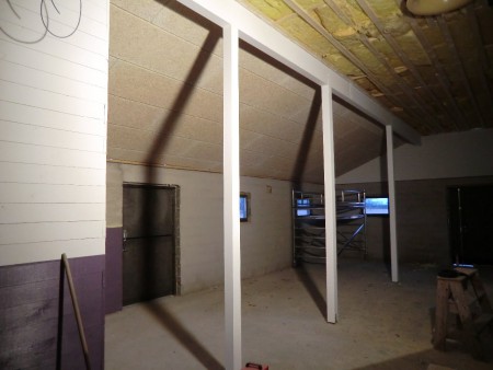 Påbörjat innertak, det är cementbundna träullsplattor, avsedda för stall. Brandtåliga, fuktsäkra och ljuddämpande, och (häst-?) svindyra! Limträbalkarna har fått två lager färg. Vi använder Teknos stallfärg.