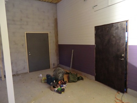 Plåtdörr in mot kallförråd och lackbetsad brun dörr till sadelkammare